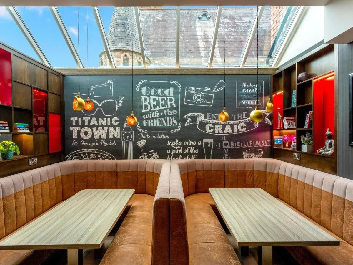 two benches in a restaurant with a chalkboard wall at ibis Belfast Queens Quarter in Belfast
